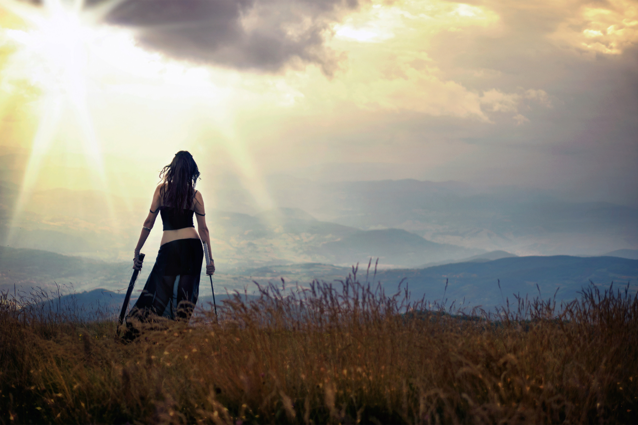 A powerful image of a woman standing confidently on a mountain top, symbolizing the courage and empowerment found in speaking one's truth and overcoming fear in relationships.